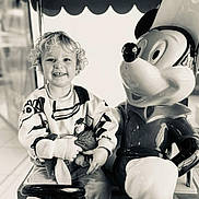 Sasha a rejoint le concours — aidez-le/la à gagner de superbes lots ! child, toddler, smiling, curly_hair, toy, stuffed_animal, mickey_mouse, statue, black_and_white, indoor, seat, clothing, happy, person, portrait, playful, cute, fun, amusement, kid