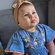 Jeanne participe au concours pour gagner de l'argent avec cette photo : baby, child, blue_dress, headband, bow, embroidery, flowers, couch, indoors, portrait, cute, infant, sitting, person, face, skin, expression, happy, necklace, soft_lighting
