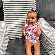 Emelia joined the competition — help win amazing prizes! baby, child, smiling, sitting, sofa, cushion, plush, indoor, clothing, hair_accessories, happy, portrait, cute, infant, furniture, fabric, texture, person, one_person, young_child