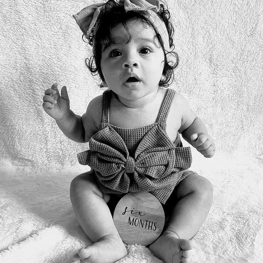 Jaleana is registered to the contest to win money with this photo: adorable, baby, big_eyes, black_and_white, bow, child, clothing, curly_hair, cute, expression, headband, indoor, infant, portrait, sitting, six_months, soft_blanket, studio, wooden_sign, young