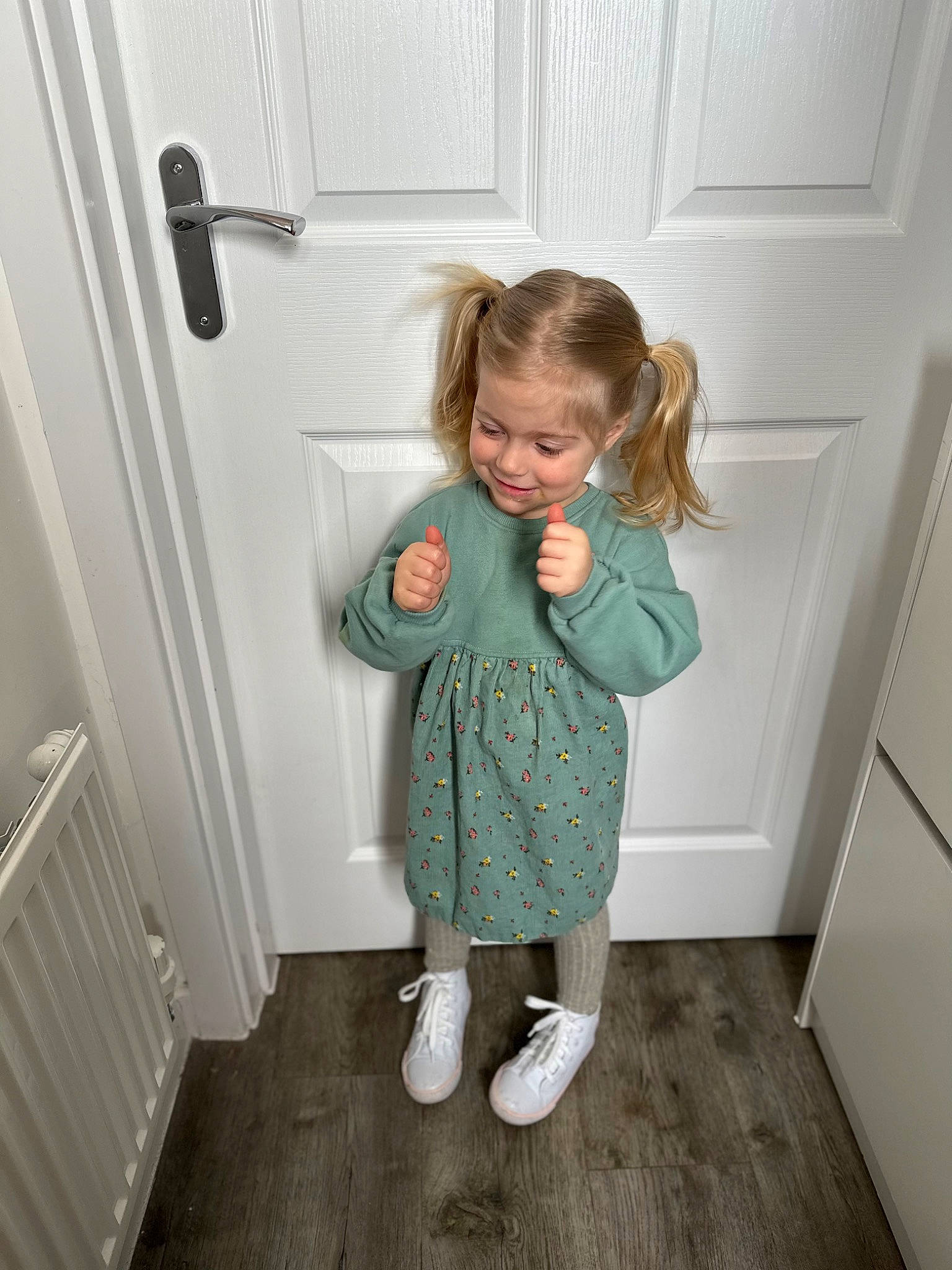 Lainey is registered to the contest to win money with this photo: baby_toddler_clothing, child, door, floor, flooring, fun, hardwood, home_door, human_leg, joy, knee, pattern, person, product, room, sleeve, sock, standing, toddler, wood