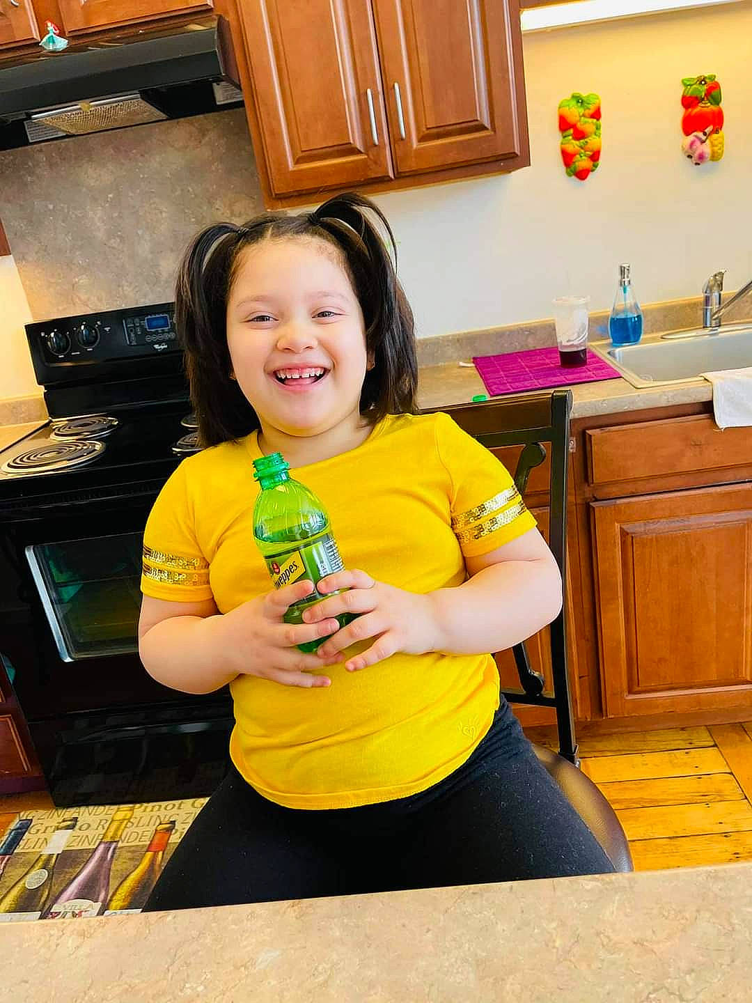 Danisha is registered to the contest to win money with this photo: bottle, cabinetry, computer_keyboard, countertop, drawer, flooring, fun, happy, hardwood, home_appliance, joy, kitchen, kitchen_appliance, major_appliance, person, plastic_bottle, room, smile, t_shirt, wood