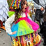 Ancana a rejoint le concours — aidez-le/la à gagner de superbes lots ! child, girl, costume, colorful, curly_hair, surprised_expression, tulle_dress, carousel_skirt, rainbow_ribbons, toy_pony, parade, crowd, street, outdoor, festive, playful, adult, sneakers, photography, portrait