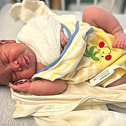 Phoenix is registered to the contest to win money with this photo: newborn, baby, sleeping, blanket, yellow, striped, frog_design, hospital_id, infant, wrapped, soft, skin, peaceful, resting, cute, small, bed, indoors, person, child