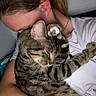 affection, animal, casual_clothing, cat, close_up, comfort, cuddle, face, friendship, hair, hug, indoor, love, paw, person, pet, relaxation, skin, tabby_cat, white_shirt