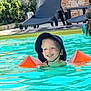 Nino participe au concours pour gagner de l'argent avec cette photo : child, boy, swimming_pool, water, floaties, sunhat, smiling, outdoor, summer, happy, swimming, people, poolside, blue_water, greenery, recreation, leisure, vacation, sunlight, fun