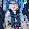 baby, car_seat, blue_hat, smiling, child, happy, infant, sitting, clothing, straps, safety_harness, cute, portrait, indoor, headwear, baby_clothes, feet, sock, seat, person