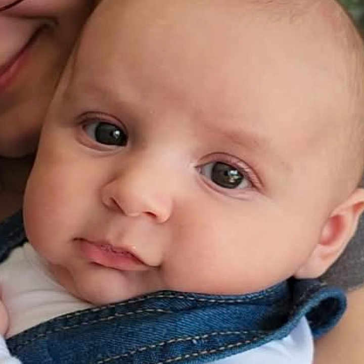 Bayn is registered to the contest to win money with this photo: baby, child, person, face, denim, overalls, white_shirt, glasses, adult, candid, indoor, cabinet, dishes, holding, portrait, closeup, skin, happy, cute, family