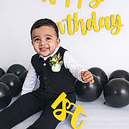 Shaurya is registered to the contest to win money with this photo: 1st_birthday, baby, birthday, black_balloons, celebration, child, cute, decorations, flower_corsage, formal_wear, happy_birthday, indoors, joyful, party, portrait, sitting, smiling, studio, suit, yellow_letters