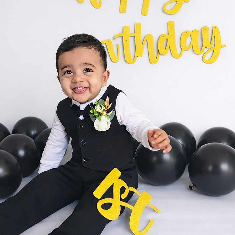Shaurya is registered to the contest to win money with this photo: 1st_birthday, baby, birthday, black_balloons, celebration, child, cute, decorations, flower_corsage, formal_wear, happy_birthday, indoors, joyful, party, portrait, sitting, smiling, studio, suit, yellow_letters