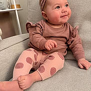 Avery is registered to the contest to win money with this photo: baby, child, headband, smile, polka_dot, leggings, sitting, armchair, cozy, cute, indoors, soft_texture, pink, clothing, happy, portrait, infant, cute_expression, furniture, warm_lighting