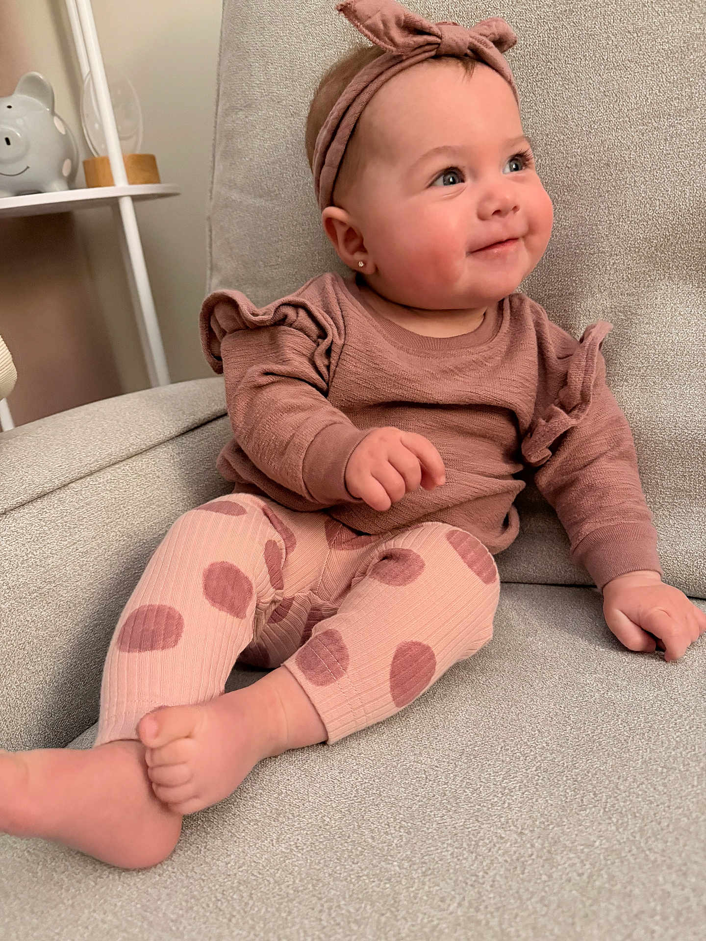Avery is registered to the contest to win money with this photo: baby, child, headband, smile, polka_dot, leggings, sitting, armchair, cozy, cute, indoors, soft_texture, pink, clothing, happy, portrait, infant, cute_expression, furniture, warm_lighting