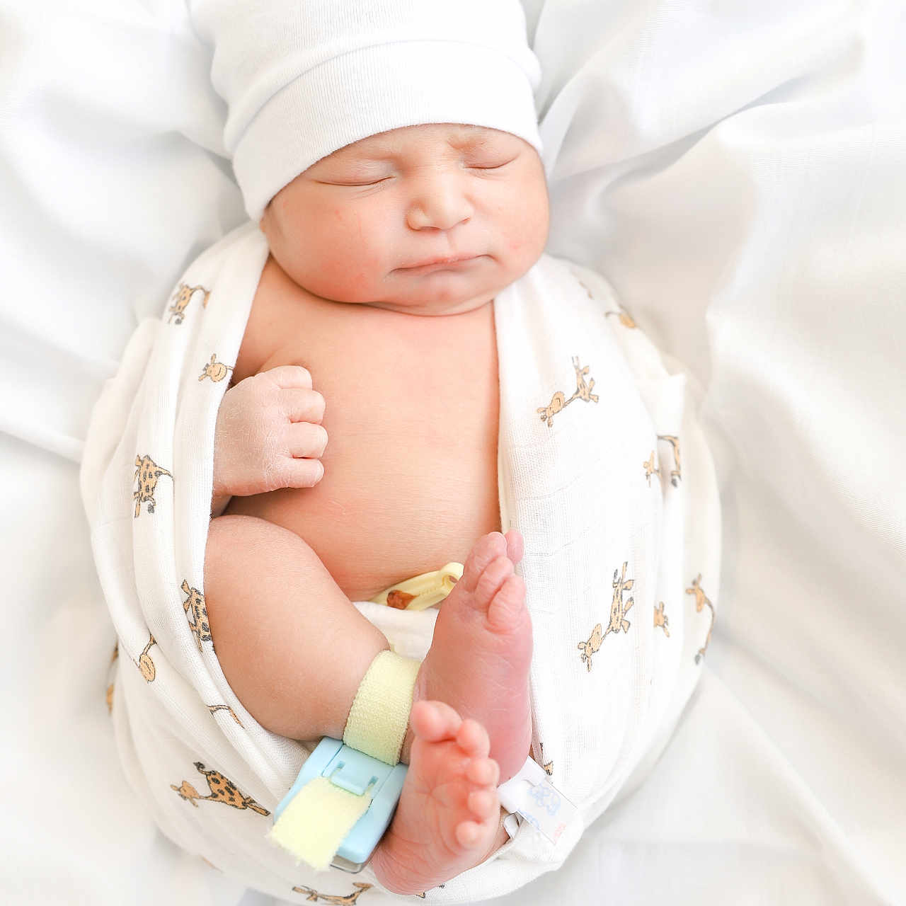 Thiago joined the competition — help win amazing prizes! newborn, baby, sleeping, swaddled, blanket, white_hat, cute, infant, soft, peaceful, wrapped, giraffe_print, small, feet, hands, indoors, portrait, human, child, resting
