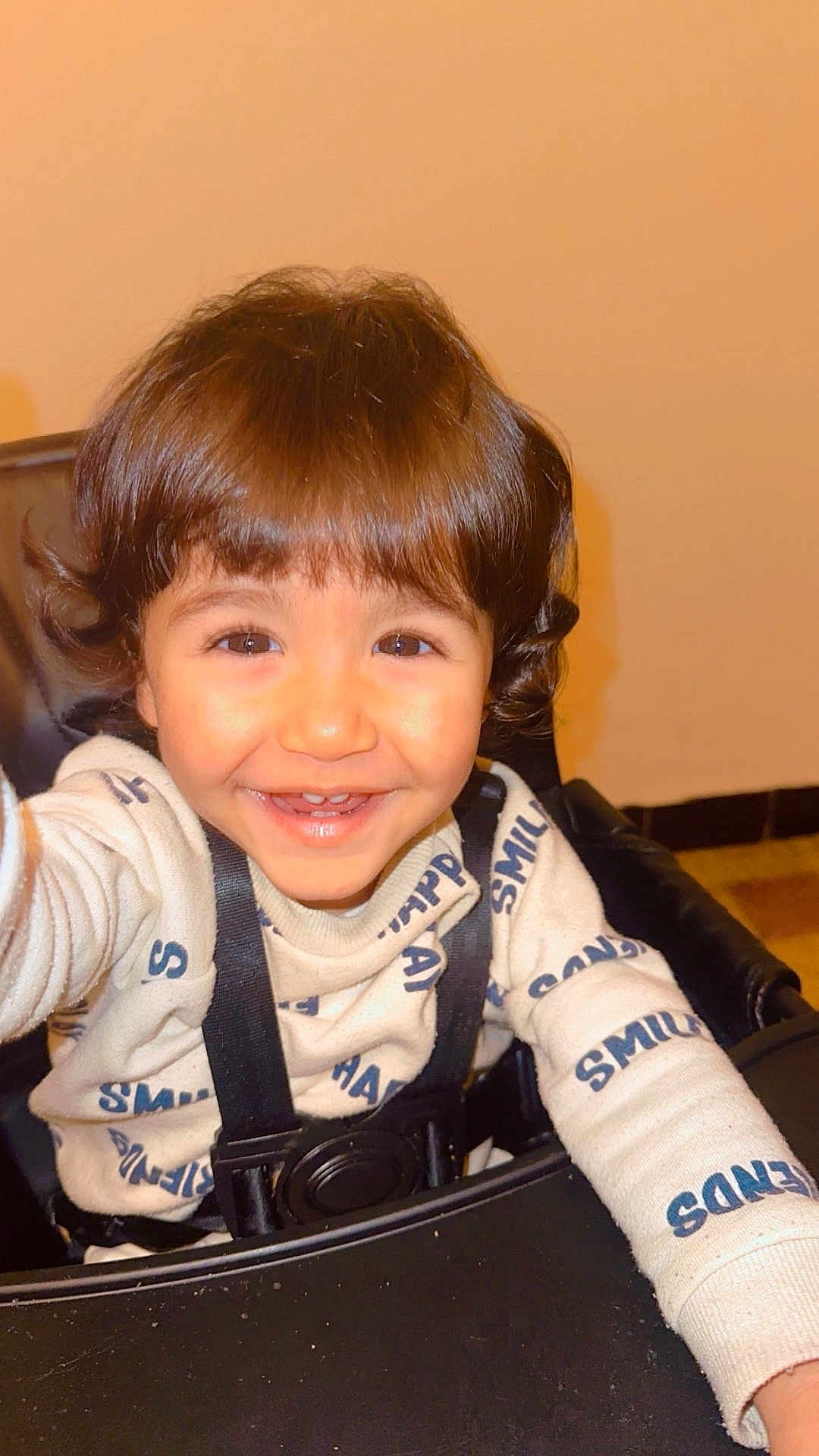 Oussaid a rejoint le concours — aidez-le/la à gagner de superbes lots ! toddler, child, smile, happy, curly_hair, sweater, high_chair, indoor, face, cute, young_child, person, cheerful, baby, portrait, seated, clothing, warm_lighting, expression, playful