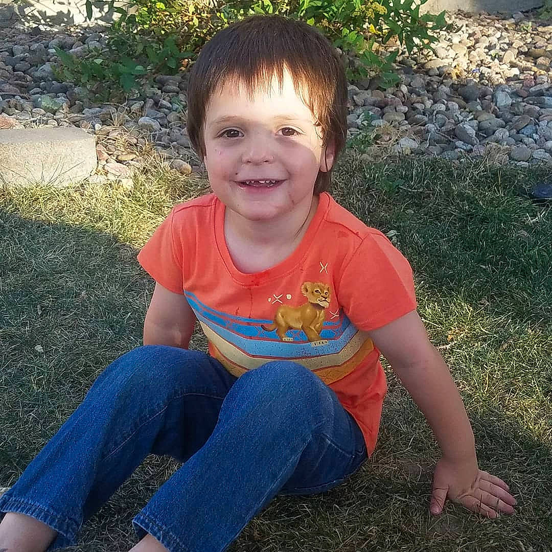 Silas is registered to the contest to win money with this photo: child, cool, eye, face, facial_expression, fun, grass, happy, head, jeans, joy, leg, people, person, plant, play, sitting, smile, summer, t_shirt