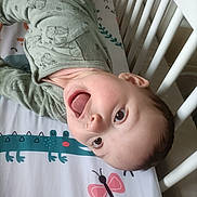 Mya a rejoint le concours — aidez-le/la à gagner de superbes lots ! baby, crib, pajamas, tongue_out, playful, child, infant, smiling, bed, animal_print, butterfly, crocodile, sleepwear, cute, happy, face, person, indoors, colorful, fun
