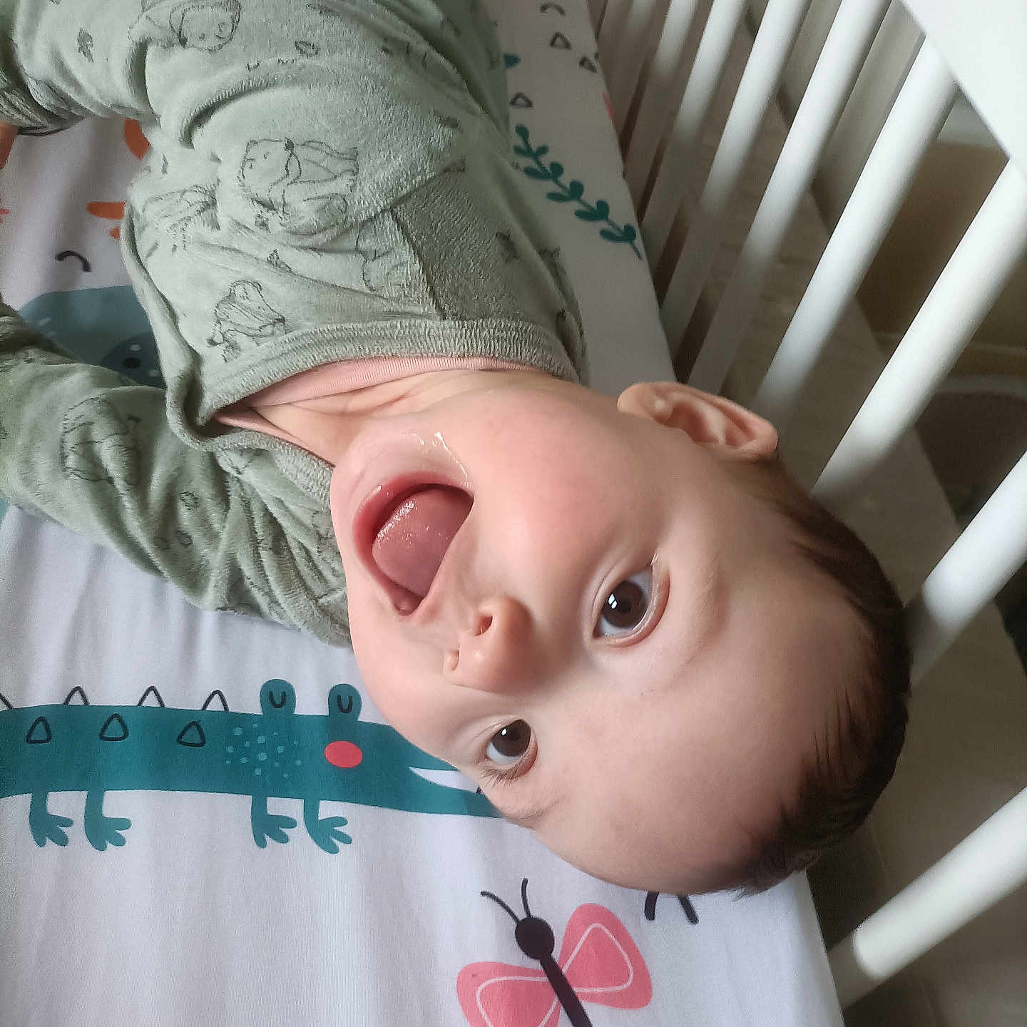 Mya a rejoint le concours — aidez-le/la à gagner de superbes lots ! animal_print, baby, bed, butterfly, child, colorful, crib, crocodile, cute, face, fun, happy, indoors, infant, pajamas, person, playful, sleepwear, smiling, tongue_out