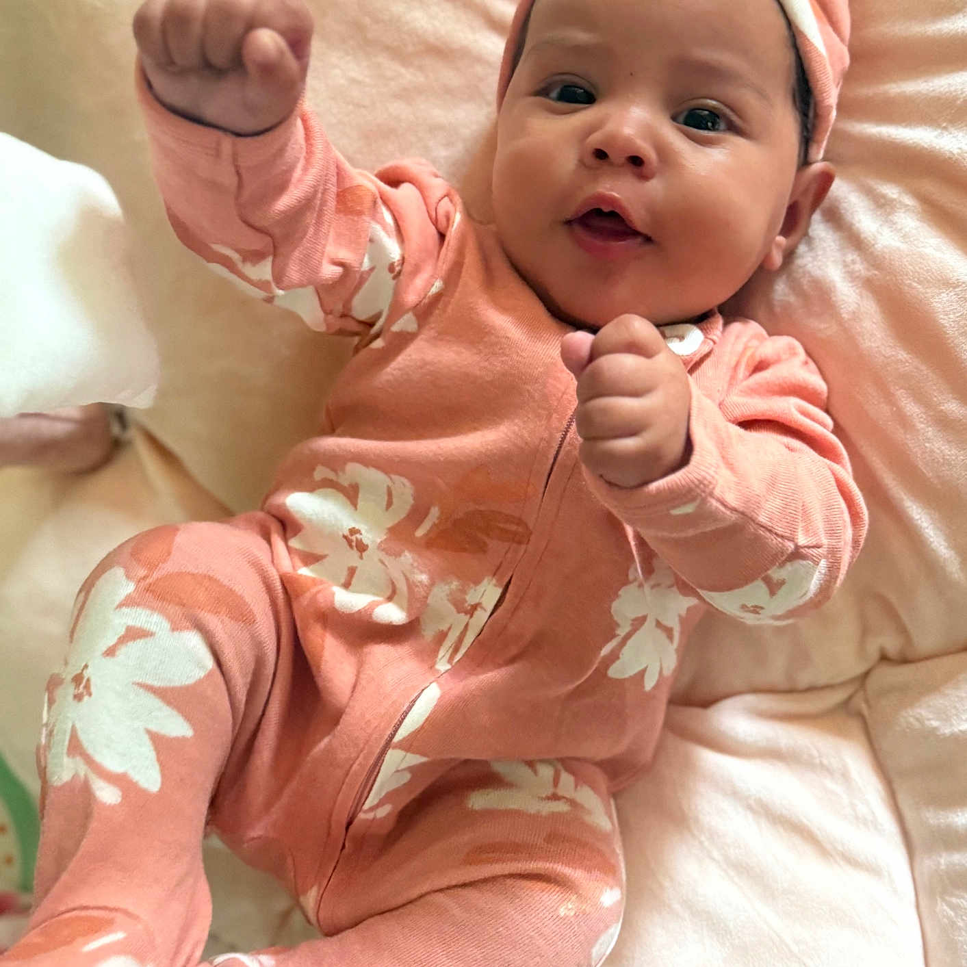 Valentina joined the competition — help win amazing prizes! baby, child, close_up, cozy, cute, face, floral_pattern, happy, headband, indoor, infant, lying_down, onesie, pink_clothing, portrait, raised_fists, skin, small_hands, smiling, soft_cushion