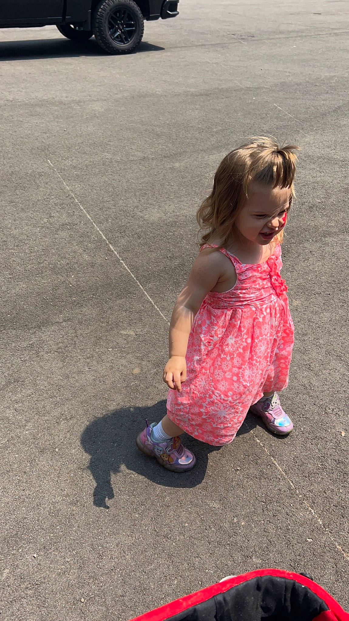 Amara is registered to the contest to win money with this photo: asphalt, baby_toddler_clothing, child, dress, foot, fun, grass, happy, human_leg, joy, leisure, magenta, pattern, people_in_nature, person, recreation, road_surface, sandal, sitting, smile