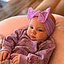 Presley is registered to the contest to win money with this photo: baby, child, infant, purple, headband, bow, clothing, blanket, couch, soft, comfortable, portrait, indoors, cute, hands, face, expression, young, sitting, cozy