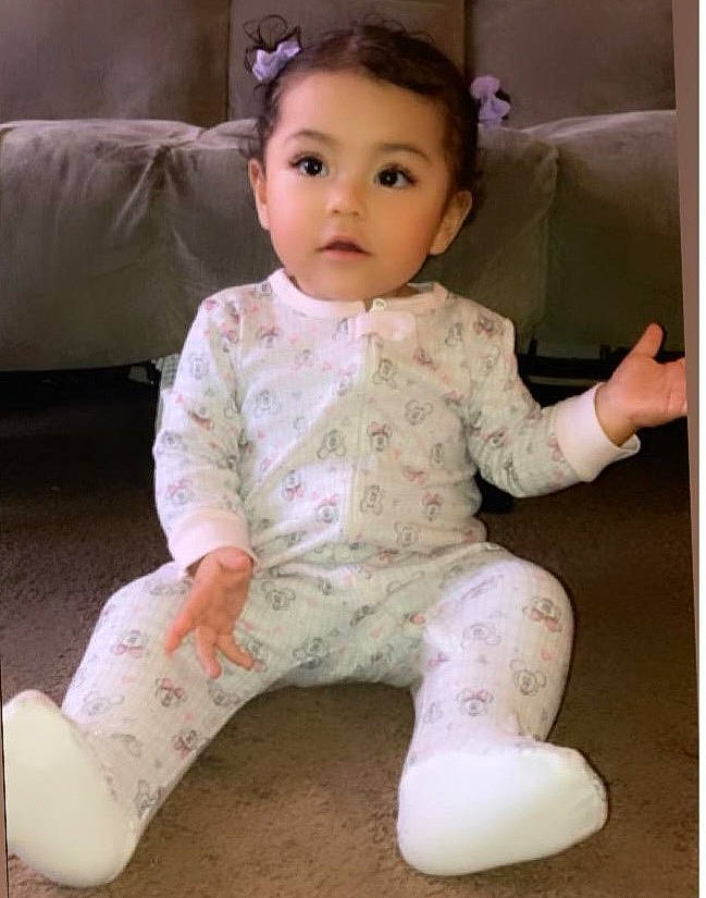 Leilah is registered to the contest to win money with this photo: baby, baby_toddler_clothing, cheek, child, comfort, eyelash, face, flooring, foot, happy, human_leg, lip, no_expression, nose, person, pink, sitting, skin, sleeve, toddler