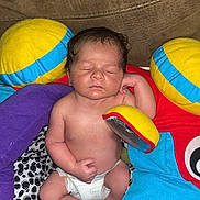 Malachi joined the competition — help win amazing prizes! baby, newborn, sleeping, diaper, plush_toys, colorful, soft, couch, infant, child, peaceful, cute, resting, indoors, person, toddler, smile, skin, hand, foot