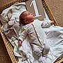 Ezra a rejoint le concours — aidez-le/la à gagner de superbes lots ! baby, newborn, infant, basket, blanket, plush_toy, bunny, onesie, white_clothing, carpet, milestone, cardboard_sign, sleeping_area, soft_texture, cozy, cute, lying_down, indoor, child, portrait