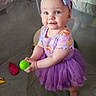 toddler, child, purple_tutu, headband, barefoot, indoor, playpen, toy_ball, smiling, baby, clothing, floor, play_area, person, cute, young_child, childhood, holding_object, infant, happy