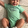 Remington is registered to the contest to win money with this photo: baby, smiling, onesie, socks, lying_down, happy, infant, child, cute, star_pattern, bed, sheet, clothing, face, legs, person, toddler, cheerful, indoor, young_child
