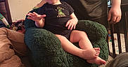 Justin joined the competition — help win amazing prizes! baby, child, infant, smiling, sitting, chair, plush_chair, adult, indoor, home, living_room, clothing, blanket, toys, furniture, portrait, barefoot, happy, family, cozy