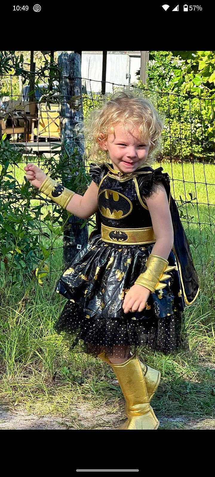 Adalyn is registered to the contest to win money with this photo: baby_toddler_clothing, blond, child, day_dress, fence, fun, garden, grass, happy, human_leg, leaf, nature, pattern, people_in_nature, person, plant, smile, spring, thigh, toddler