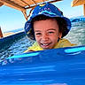 blue, bucket_hat, child, curly_hair, happy, laughing, ocean, outdoors, playful, pool, portrait, seaside, smiling, splashing, summer, swimming, vacation, water, water_slide, yellow_shirt
