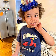 Adam joined the competition — help win amazing prizes! birthday, blanket, cabinet, celebration, chair, child, clothing, curly_hair, happy, home, indoors, party_blower, party_hat, portrait, scooter_design, seated, smiling, t_shirt, table, toddler