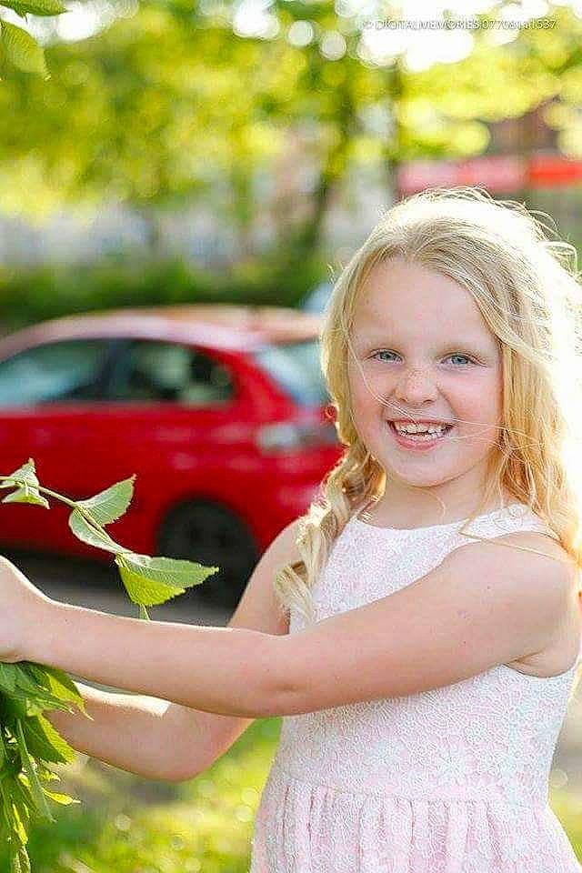 Courtney is registered to the contest to win money with this photo: blond, child, daughter, fun, girl, grass, happiness, human_hair_color, joy, pink, plant, play, sitting, smile, spring, summer, toddler