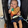 Elijah joined the competition — help win amazing prizes! baby, stroller, pacifier, bib, child, infant, hand, footwear, toy, cushion, fabric, person, clothing, seatbelt, indoor, cute, sitting, expression, head_support, foot
