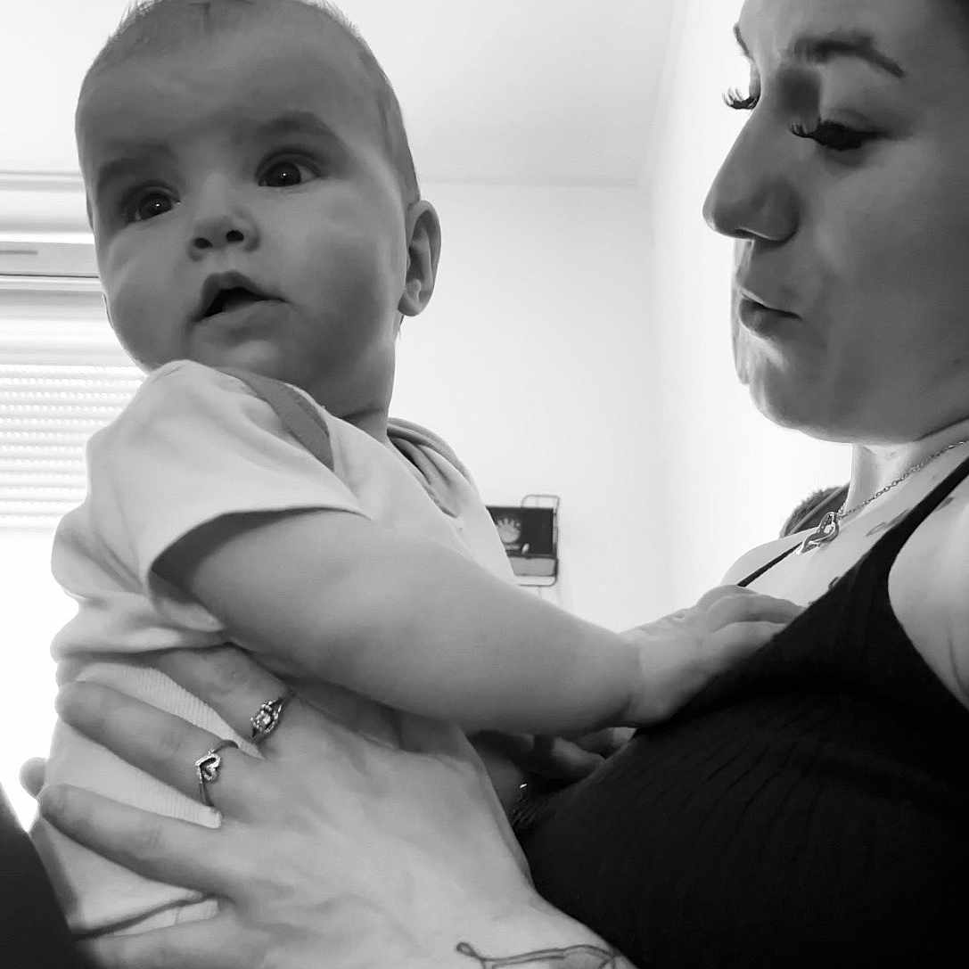 Adryanna participe au concours pour gagner de l'argent avec cette photo : adult, arm, baby, black_and_white, child, closeup, clothing, curious, expression, face, hand, holding, indoor, light, love, person, portrait, skin, tattoo, window