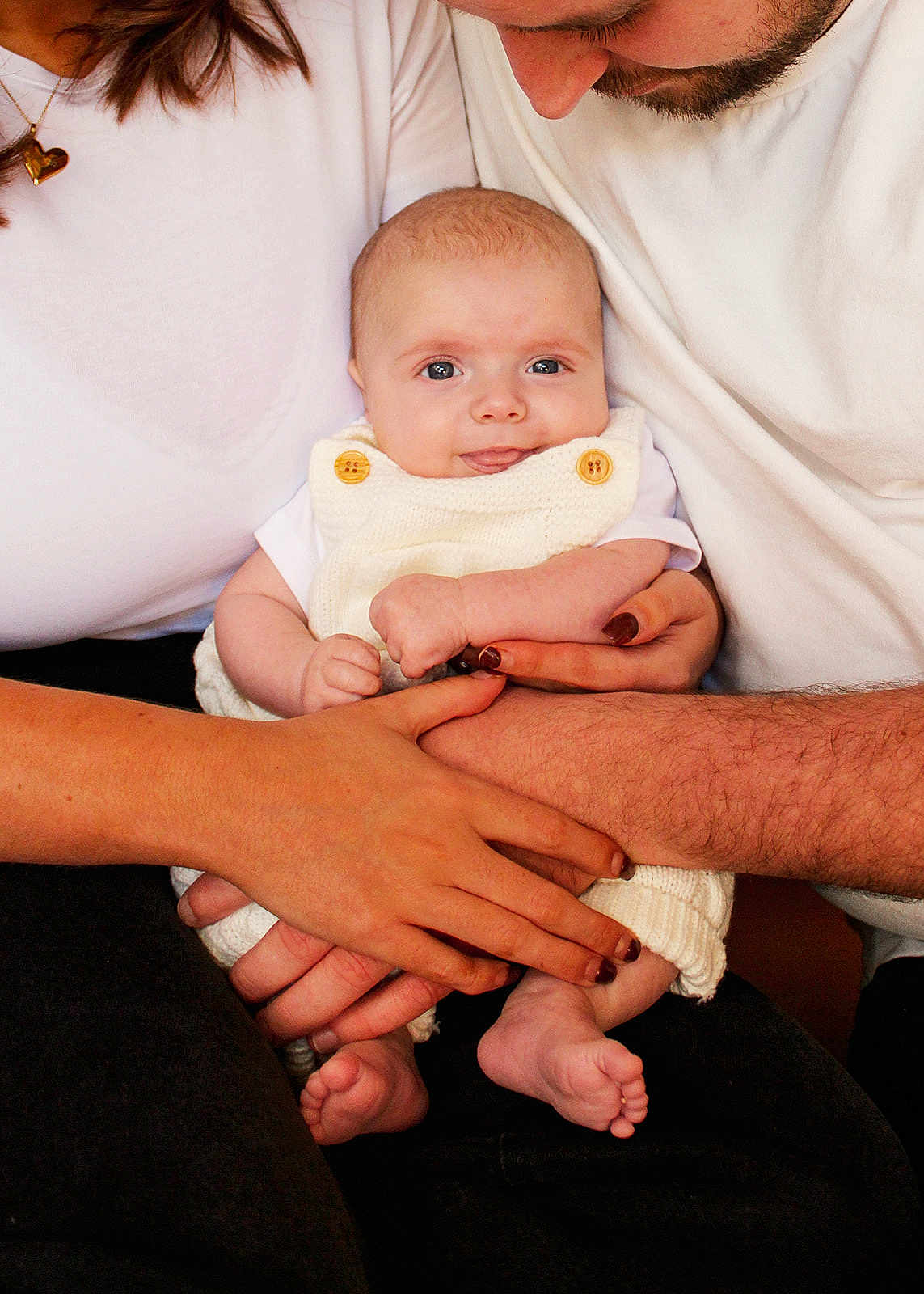 Cillian is registered to the contest to win money with this photo: baby, infant, hands, white_clothing, knitwear, family, love, parent, mother, father, skin, closeup, cute, happy, holding, toddler, smile, portrait, together, cozy