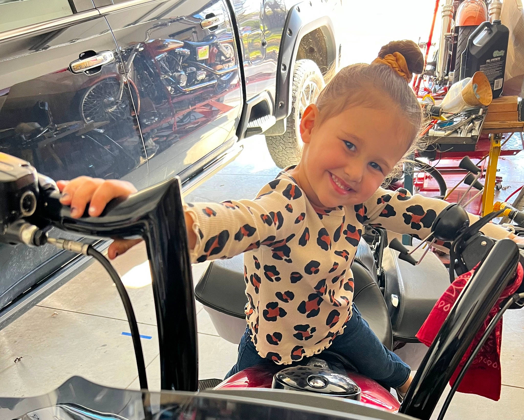 Giavonna is registered to the contest to win money with this photo: auto_part, automotive_design, automotive_exterior, automotive_lighting, automotive_tire, fender, hood, jacket, joy, leisure, mode_of_transport, motor_vehicle, person, recreation, smile, sneakers, steering_wheel, tire, toddler, vehicle