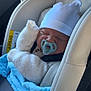 baby, pacifier, car_seat, blanket, hat, clothing, infant, sleeping, child, seatbelt, knitwear, blue, white, cozy, newborn, indoors, transportation, car, comfort, peaceful