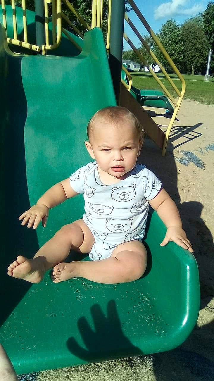 Cashton is registered to the contest to win money with this photo: child, fun, leisure, outdoor_play_equipment, person, play, playground, playground_slide, public_space, recreation, sitting, swing, toddler