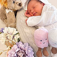 Dakota joined the competition — help win amazing prizes! newborn, baby, sleeping, infant, portrait, plush_toy, stuffed_lion, stuffed_animal, flowers, bouquet, blanket, knitted_blanket, white_clothing, bonnet, peaceful, indoors, cozy, nursery, closeup, smiling_toy