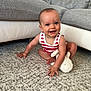 baby, child, smiling, indoor, carpet, plush_toy, striped_clothing, couch, furniture, happy, cute, sitting, infant, person, young_child, home, floor, playful, bright, portrait