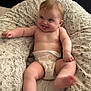 baby, diaper, infant, cushion, fluffy, bed, playful, tongue_out, skin, person, smiling, happy, cute, sitting, indoors, comfort, soft, head, legs, arms