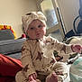 Aiyla joined the competition — help win amazing prizes! baby, child, onesie, headband, carpet, indoor, furniture, sofa, blanket, door, foot, hand, person, cute, expression, sitting, home, infant, toddler, clothing