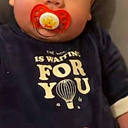 Aylan participe au concours pour gagner de l'argent avec cette photo : baby, pacifier, onesie, hand, infant, child, cushion, clothing, face, portrait, person, young, cute, lying_down, indoor, toddler, expression, skin, head, comfort