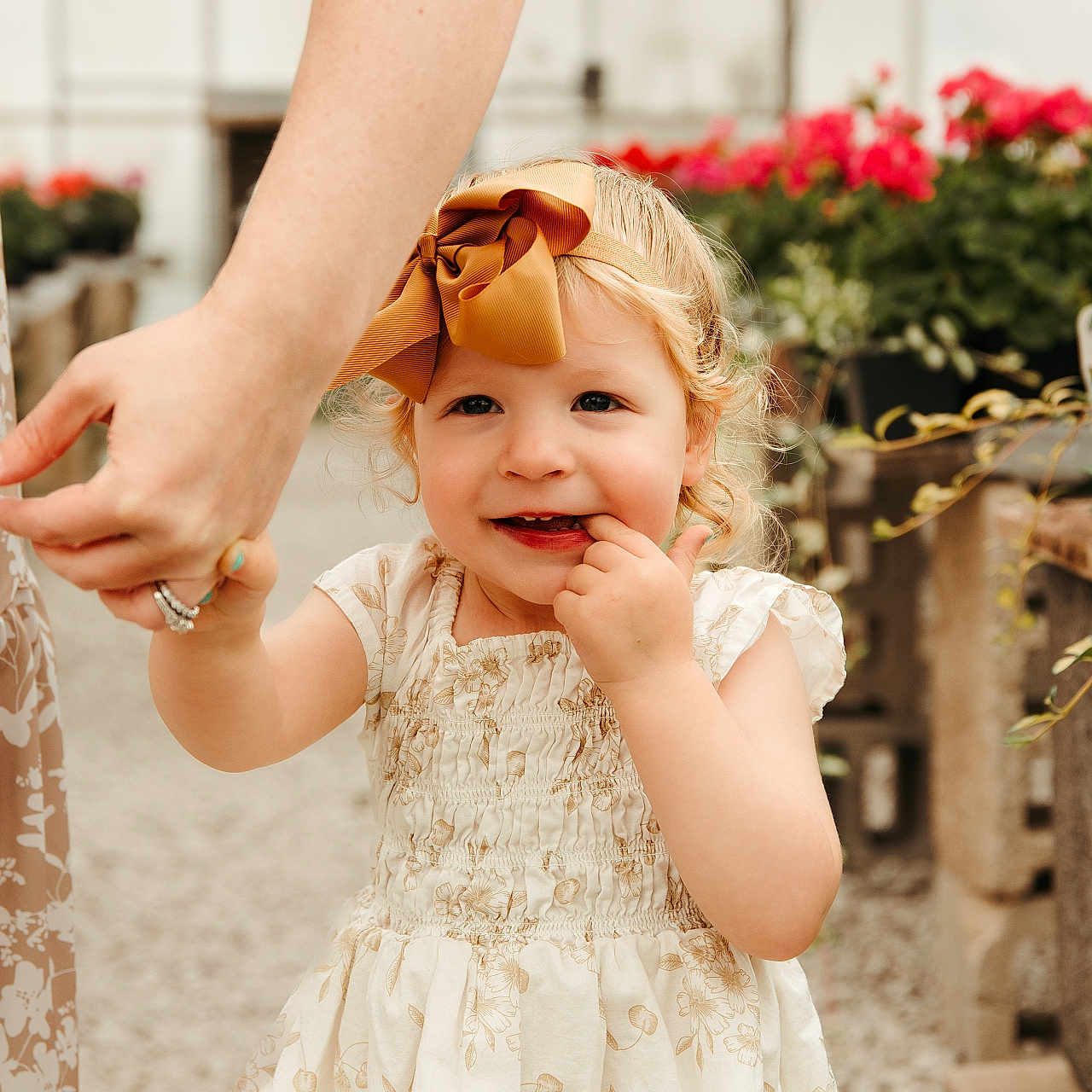 Diem joined the competition — help win amazing prizes! adult_hand, bow, casual, child, curly_hair, cute, dress, flower_pots, greenhouse, happy, holding_hand, nature, outdoor, person, plants, playful, portrait, smiling, summer_dress, toddler