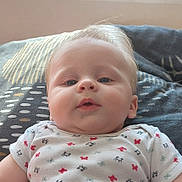 Kenzo participe au concours pour gagner de l'argent avec cette photo : baby, blanket, blonde_hair, blue_eyes, child, closeup, clothing, cute, expression, face, head, indoor, infant, lying_down, patterned_shirt, person, portrait, skin, soft_light, young_child