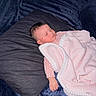 baby, baby_clothing, bed, blanket, closed_eyes, cozy, dark_background, floral_pattern, indoors, infant, nap, newborn, peaceful, photography, pillow, pink_blanket, portrait, resting, sleeping, soft_texture