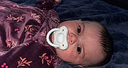 Iyla joined the competition — help win amazing prizes! baby, bed, bedroom, blanket, child, cozy, dark_lighting, eyes, face, floral_blanket, foot, hair, home, indoor, infant, infant_clothing, lying_down, pacifier, portrait, sleeping_area