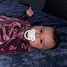 baby, bed, bedroom, blanket, child, cozy, dark_lighting, eyes, face, floral_blanket, foot, hair, home, indoor, infant, infant_clothing, lying_down, pacifier, portrait, sleeping_area